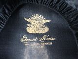 the label of a black hat with a gold eagle on it