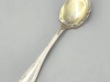 a close up of a spoon with a spoon handle on a gray surface