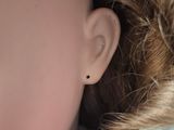 a close up of a doll ' s face and ear