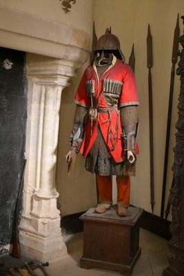 une statue représentant un homme en armure dans une pièce dotée d'une cheminée