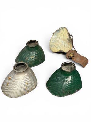 trois lampes vertes et blanches posées sur une surface blanche, munies d'une poignée en bois
