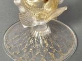 a glass figurine of a gold fish on a clear plate