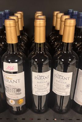 several bottles of wine are lined up on a shelf in a store