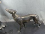 statue of a woman and a dog on a black surface