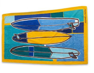 yellow beach towel with surfboards on it on a blue and green background