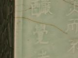 a green vase with chinese writing on it in a room