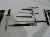 plusieurs types de couteaux sont présentés sur un tissu blanc