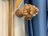 a gold lion head hanging on a blue curtain