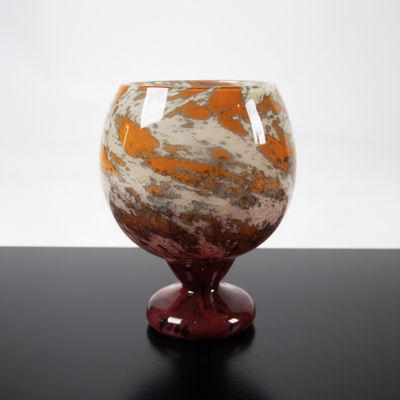 a glass vase with a red base on a table