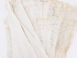 four white napkins with lace on them on a white surface