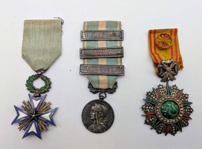 trois médailles et une médaille sur une surface blanche