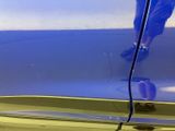 a close up of a blue car with a person standing on it
