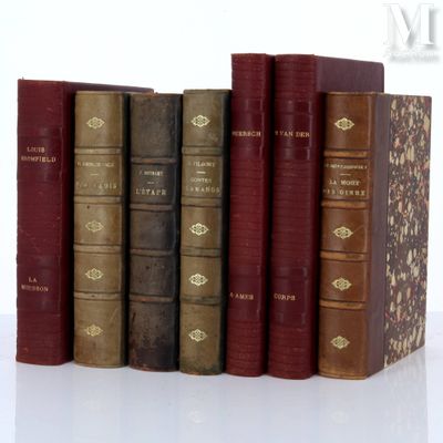 several old books are lined up in a row on a white surface