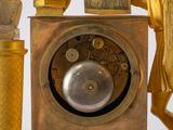 a gold clock with a statue on top of it
