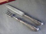 two knives and a fork on a table