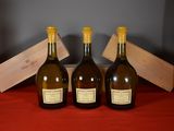 three bottles of wine sit on a red cloth next to a wooden box