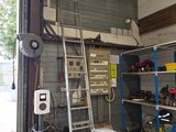 une photo d'un garage avec une échelle et un établi
