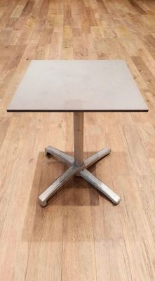 une table blanche avec un piètement argenté posée sur un parquet