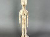 a white statue of a man standing on top of a black base