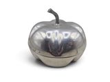 une boîte argentée en forme de pomme posée sur une surface blanche