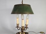 une lampe de table ancienne en laiton avec un abat-jour vert et trois bougies