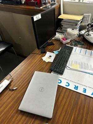 un bureau sur lequel se trouvent un ordinateur portable, un clavier, une souris et des papiers