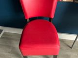 a red chair sitting in front of a blue wall