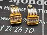 une paire de boucles d'oreilles en or et diamants posée sur un calendrier