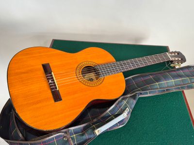 une guitare posée sur un livre vert