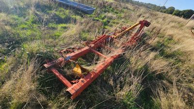a small tractor that is laying in the grass