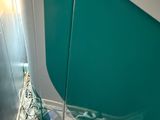 un voilier avec une voile bleue et blanche sur l'eau
