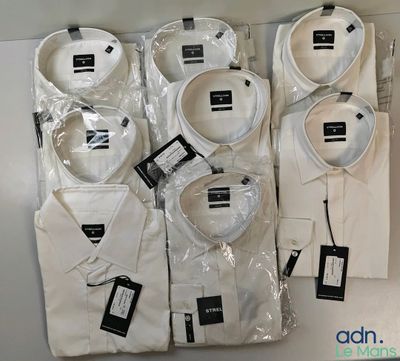 several men ' s white dress shirts in plastic bags on a table