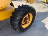 a large yellow tractor with a big tire on the ground