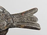 a metal bird that is sitting on top of a table