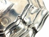 a close up of a silver object on a white surface