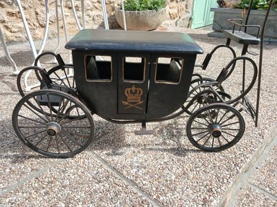 une calèche tirée par un cheval noir, garée sur le gravier