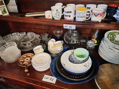 many plates and cups on a shelf in a room