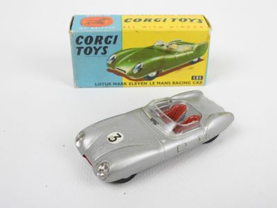 une petite voiture argentée posée à côté d'une boîte de jouets