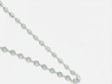 un gros plan sur un long collier orné d'une croix