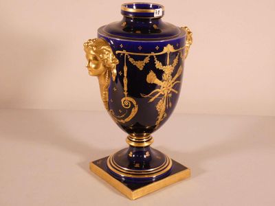 a blue vase with gold decoration on it on a table