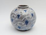 un vase bleu et blanc posé sur une surface blanche