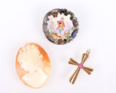 trois bijoux, dont une croix, un coquillage et une broche