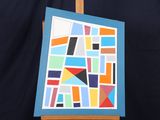 un chevalet sur lequel est posée la reproduction d'un tableau, sur fond noir