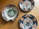 three plates that are sitting on a wooden floor