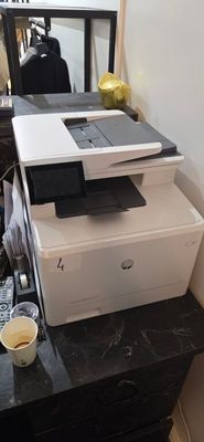 une imprimante posée sur une commode, à côté d'un miroir