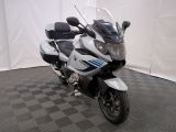une photo d'une moto blanche et noire garée sur un sol à damier