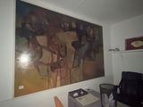 a painting on the wall above a desk in a room