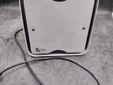 une petite enceinte blanche posée sur une table à côté d'une souris