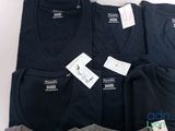 three men ' s t - shirts sitting on top of each other on a table
