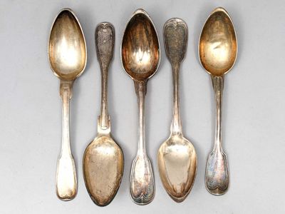 six cuillères sont alignées sur une surface blanche
